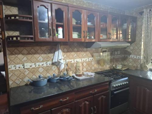 a kitchen with wooden cabinets and a stove at P Square Apartment in Morogoro