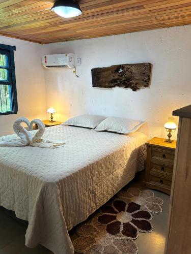 a bedroom with a bed with a white bedspread at Casa Ar Fresco in Sapiranga