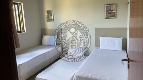 a pair of beds in a small room at Refúgio Serrano Bananeiras in Bananeiras