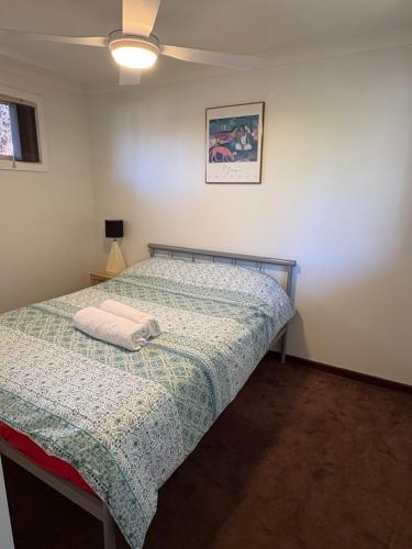 a bedroom with a bed with a blanket on it at 2x1 granny flat close to Perth Airport in Perth