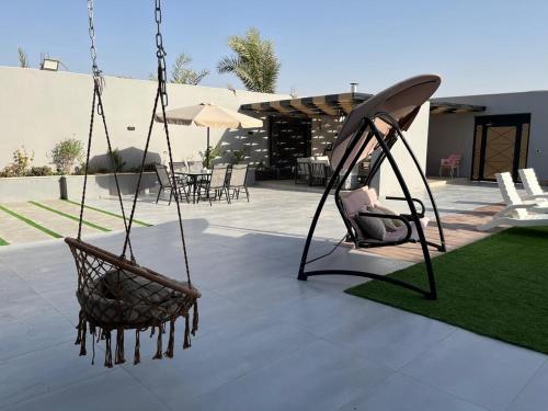 a swing with a chair on a patio at عمان البحر الميت in Sowayma