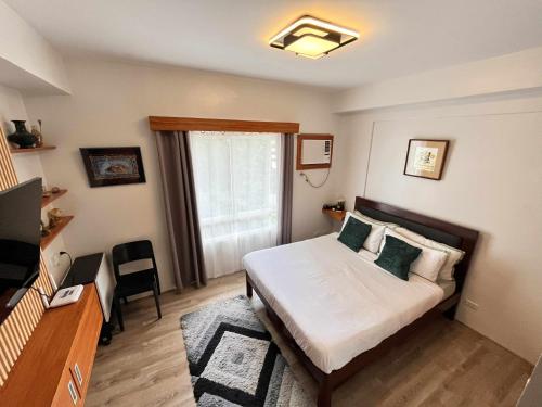 a small bedroom with a bed and a window at Casa Ljea in Bacolod