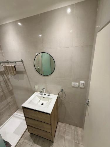 a bathroom with a sink and a mirror and a shower at Departamento céntrico in Olavarría