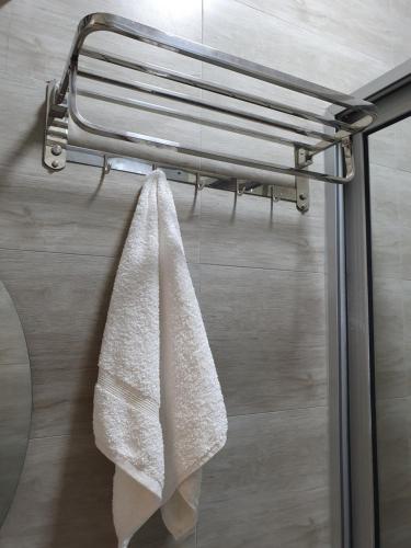 a towel hanging on a towel rack in a bathroom at Big H Apartments - 2 bedrooms - 2 bathrooms - Sittingroom - kitchen - free parking- free wifi - Fully furnished in Kitende