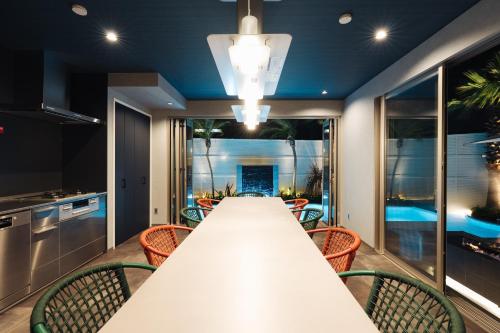 a large dining room with a long table and chairs at The Pool House Tokyo Bay in Narashino