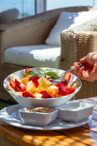 a person eating a bowl of fruit on a table at Bora Bora Beach Club Cartagena in Isla Grande