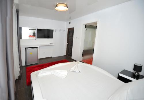 ヴァルナ・シティにあるPoshta 1 Apartment 1のベッドルーム1室(白いベッド1台、赤いラグ付)