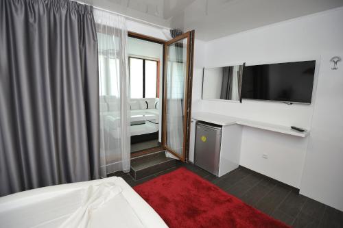 ヴァルナ・シティにあるPoshta 1 Apartment 1のベッド、テレビ、鏡が備わるホテルルームです。