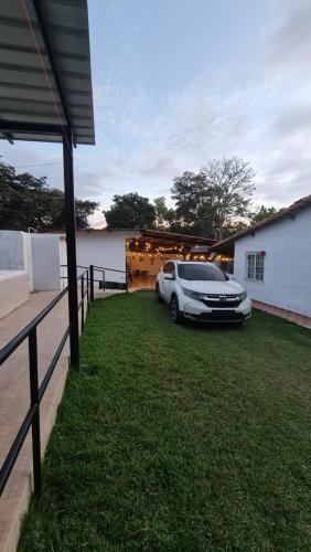 a car parked in a yard next to a house at Las Guias Cabaña Privada in Río Hato