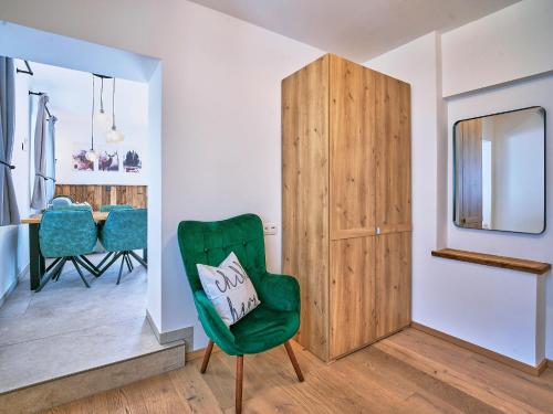 sala de estar con silla verde y almohada en ALP'N SOUL - AlpenLuxus Collection, en Voldöpp