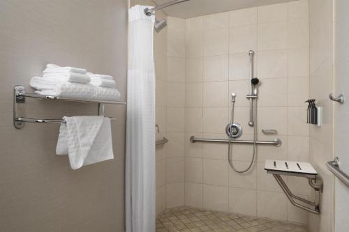a bathroom with a shower with white towels at The DEXTRO Little Italy, BW Premier Collection in San Diego
