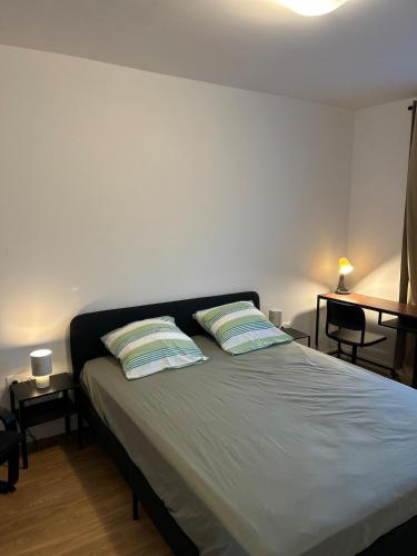 ein Schlafzimmer mit einem Bett mit zwei Kissen darauf in der Unterkunft Chic 2 chambres appartement proche de Paris in Vitry-sur-Seine