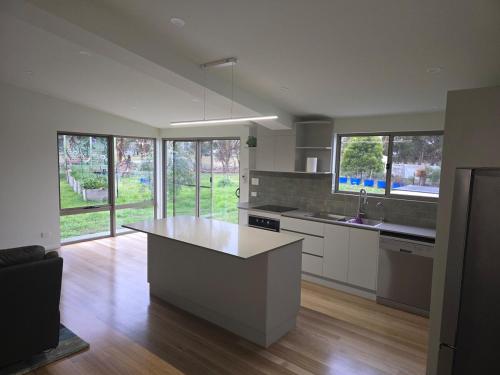 a kitchen with a island in the middle of it at Urban Retreat near Hobart & Airport, Port Arthur in Penna