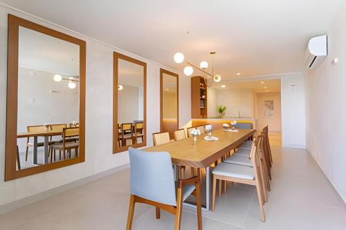 Un comedor con mesa y sillas de madera. en Beira-Mar Boa Viagem - Ivone Asfora by Bnb Flex, en Recife