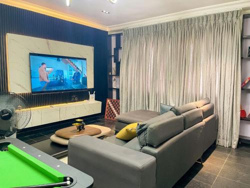a living room with a couch and a pool table at Soothing Haven in Ibadan