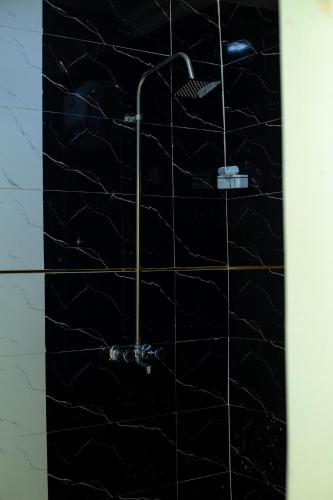 un bagno con doccia con piastrelle nere di Soothing Haven2 a Ibadan
