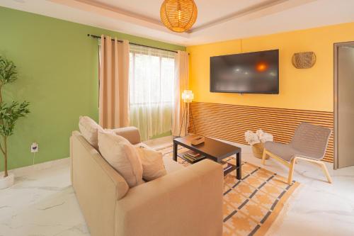 a living room with a couch and a tv at Casa Olivo in Mexico City