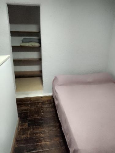 a small room with a bed and a staircase at Alojamiento Libertador in Alta Gracia