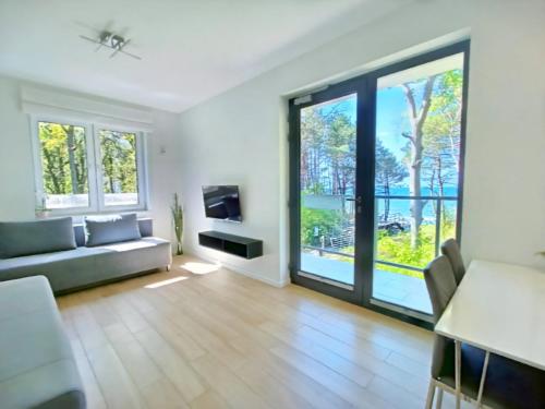 a living room with a couch and a tv at SEA & YOU Apartament z widokiem na morze - Dwie Sosny in Ustronie Morskie