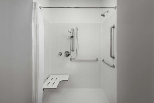 a white bathroom with a shower with a door at StudioRes by Marriott Fort Myers Airport in Miromar Lakes