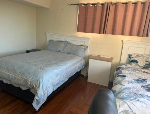 a bedroom with two beds and a couch in it at Granadilla st 超大间2张床走路到公交站商场2 in Brisbane