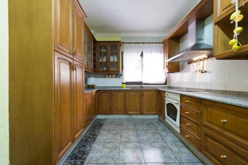 cocina grande con armarios de madera y lavavajillas en Rincón Mirador Risco Verde, en Arinaga