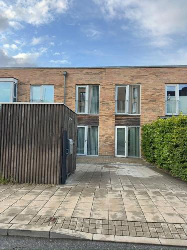 a brick building with a fence in front of it at Cozy Townhouse near Copenhagen in Rødovre