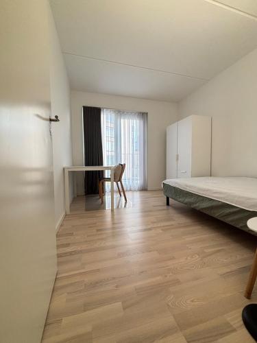 een lege kamer met een bed en een bureau bij Cozy Townhouse near Copenhagen in Rødovre