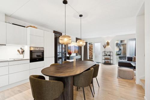 une cuisine et une salle à manger avec une table et des chaises en bois dans l'établissement Cozy Townhouse near Copenhagen, à Rødovre