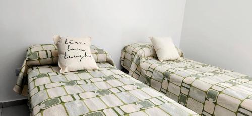 two beds sitting next to each other in a room at Alojamiento Mavic - Amueblados Comahue in Cipolletti