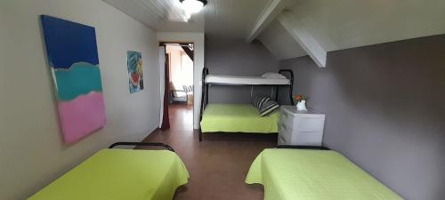 two beds in a room with green sheets at The Nest Rainforest Retreat in Panama City