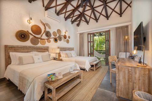 - une chambre avec 2 lits, une table et une télévision dans l'établissement Casa Jacaranda Hotel Boutique by HMC -Cauca Viejo- Mayores de 14 años, à Jericó