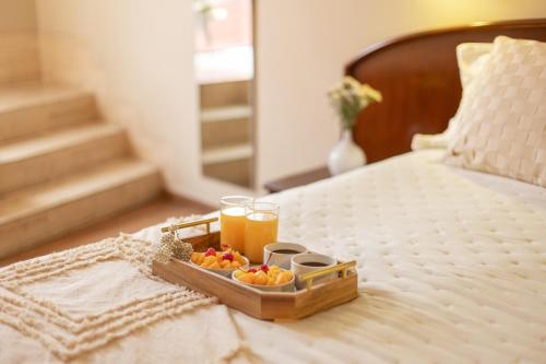 a tray of fruit and a glass of orange juice on a bed at Hotel Park Suites in Lima