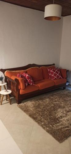 un sofá naranja en una sala de estar con alfombra en Sítio Morada de Deus, en Guapimirim