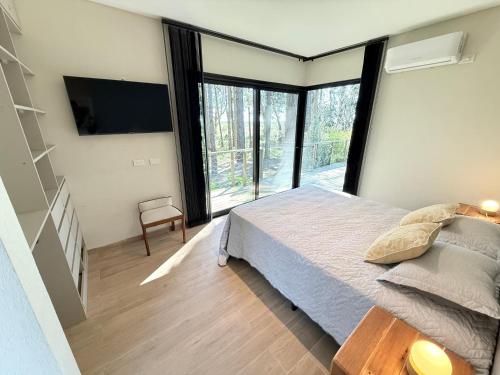 a bedroom with a bed and a large window at Casa en Costa Esmeralda Descanso y Relax Premium 8 Pax in Costa Esmeralda