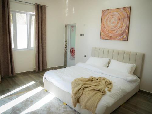 a bedroom with a white bed with a blanket on it at Beit Ward Al Jabal in Sayq