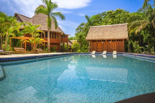 a large swimming pool in front of a house at IKAM Riverview Amazon Lodge - Asociado Casa Andina in Puerto Maldonado