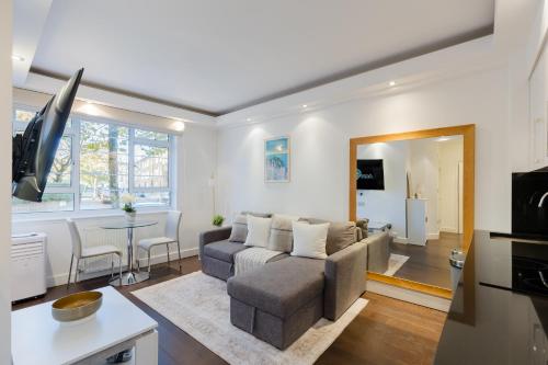 a living room with a couch and a table at Chelsea Luxe in London