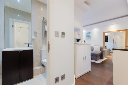 a bathroom with a sink and a toilet in a room at Chelsea Luxe in London