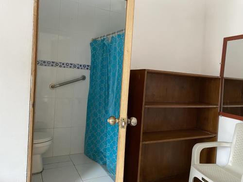 a bathroom with a shower curtain and a toilet at Hostal La Cabaña Típica in Playas