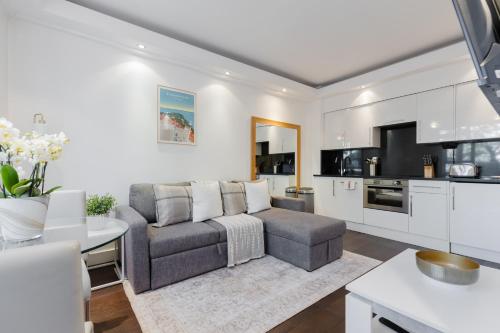 a living room with a couch and a table at Chelsea Luxe in London