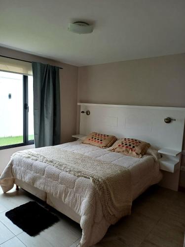 ein Schlafzimmer mit großem Bett und Fenster in der Unterkunft El Descanso in Olavarría