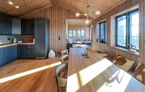 a kitchen and living room with a long wooden table at Stunning Home In Noresund With Sauna in Surteberg