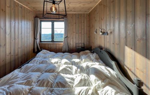 a large bed in a room with wooden walls at Stunning Home In Noresund With Sauna in Surteberg