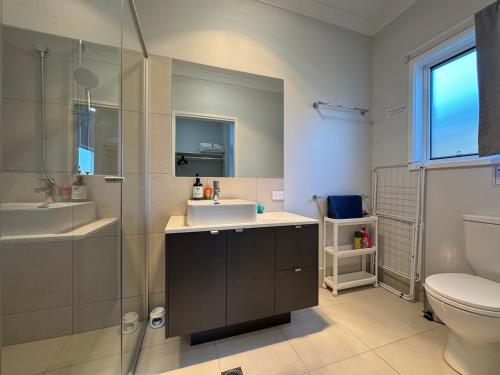 a bathroom with a sink and a toilet and a shower at Hillcrest Retreat - Cozy Studio with Private Entry in Boronia Heights