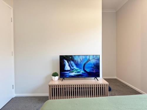 a flat screen tv sitting on a stand in a room at Hillcrest Retreat - Cozy Studio with Private Entry in Boronia Heights