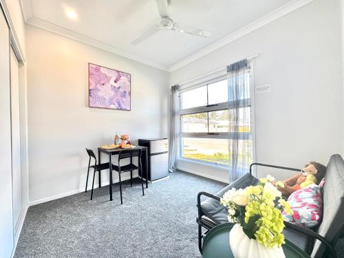 a living room with a table and a couch at Hillcrest Retreat - Cozy Studio with Private Entry in Boronia Heights