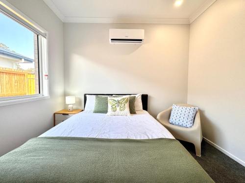a small bedroom with a bed and a chair at Hillcrest Retreat - Cozy Studio with Private Entry in Boronia Heights