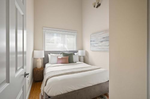 ポートランドにあるTrendy NW Portland Getaway - Walk to Dining & Barsのベッドと窓のある白い寝室