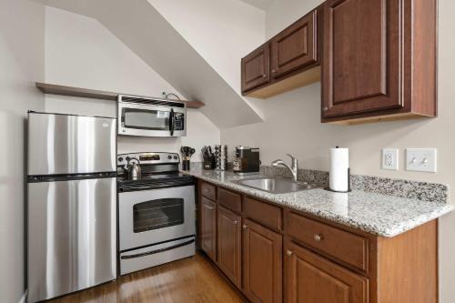 ポートランドにあるTrendy NW Portland Getaway - Walk to Dining & Barsのキッチン(ステンレス製の電化製品、木製キャビネット付)